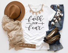Load image into Gallery viewer, White faith over fear t shirt front view with floral necklace styled with hat scarf jeans and leopard flats

